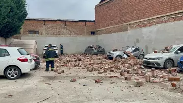 Rüzgarın devirdiği çatı duvarı ve hasar gören araçlar