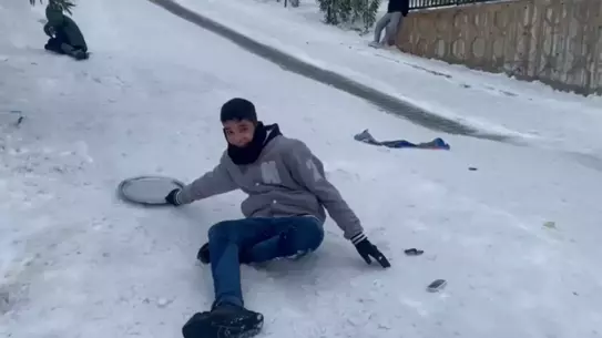 Çocuklar tepsi ve poşetle kayıyor