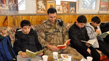 Etkinlikte polis memurlarıyla birlikte kitap okuyan çocuklar