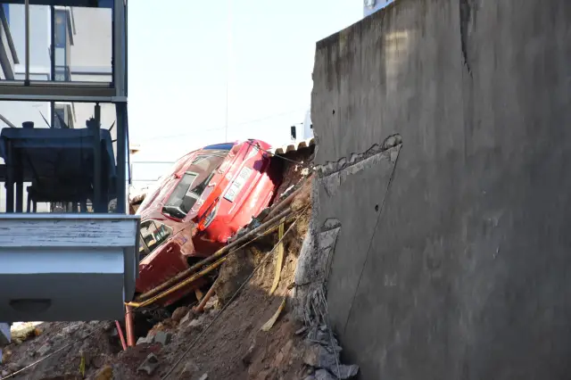 Çöken duvarın önündeki hasarlı araçlar