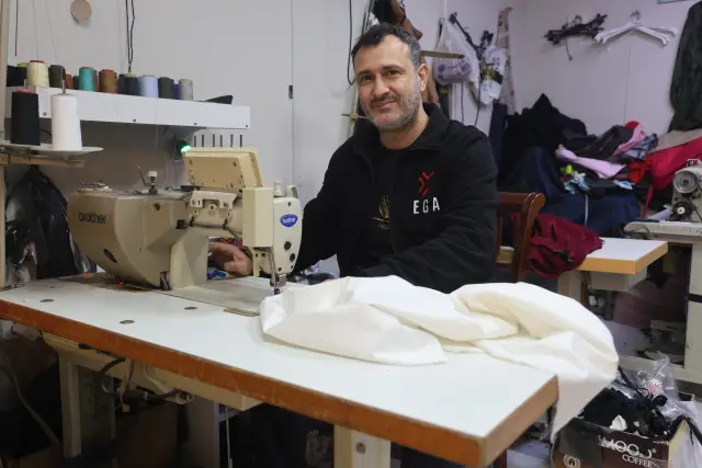 Camda asılı “Kefene cep dikilir” yazısı ve meraklı vatandaşlar