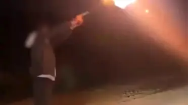 Havaya ateş açan kişi silahını gösteriyor