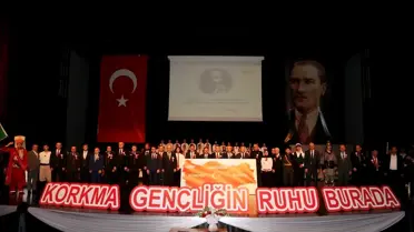 Etkinlikte sahnede İstiklal Marşı okuyan gençler