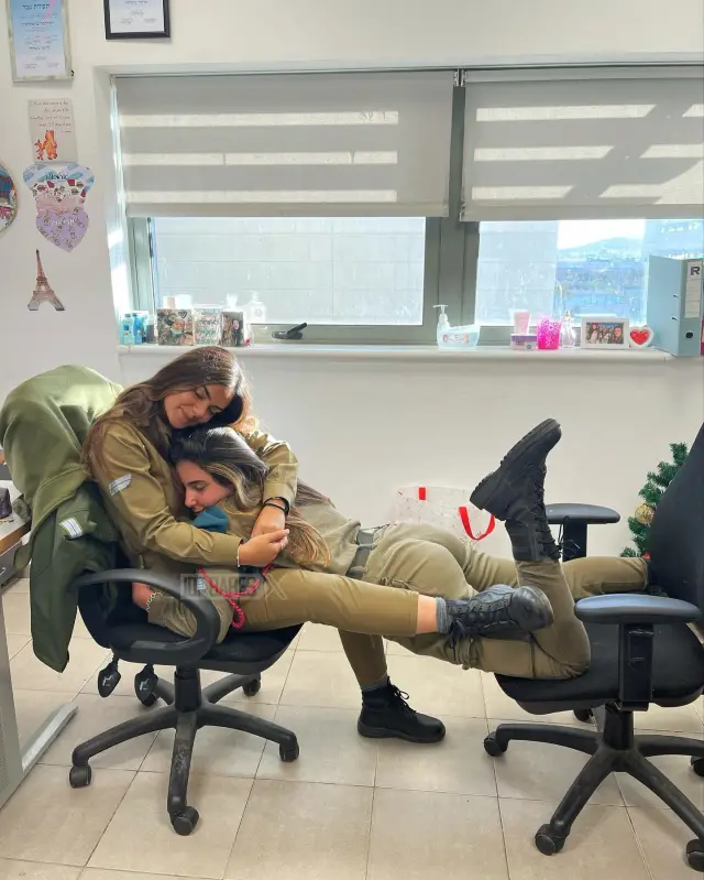 Asker, silahını çiçek tutacak gibi tutuyor