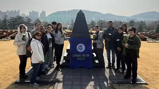 Öğrenciler mezarlıkta çiçek bırakıyor