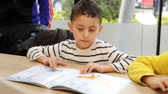 Kitap kafesinde okuma etkinliği yapan çocuklar