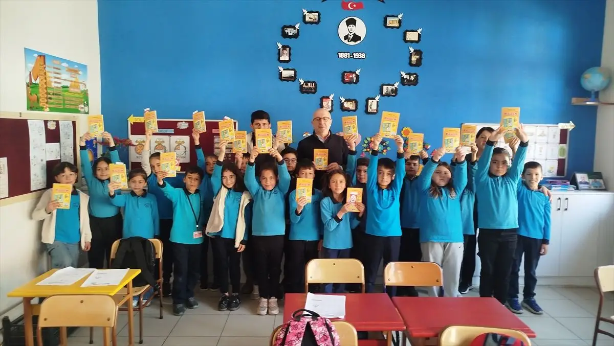 Erdoğan Car ilkokulda öğrencilere kitap imzalıyor