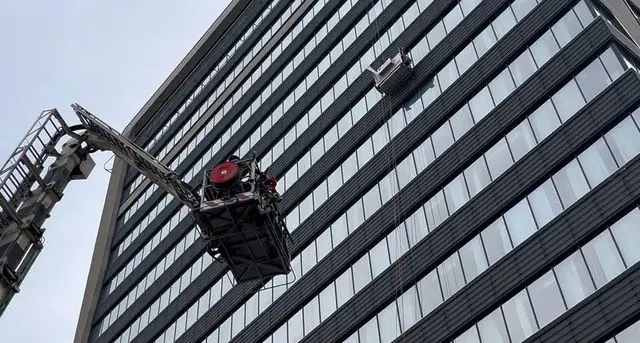 Asansör arızası sırasında dış cephede cam temizleyen işçiler